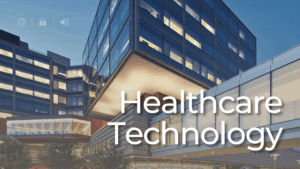 Stanford Health Care hospital with glass skybridge and courtyard at dusk.