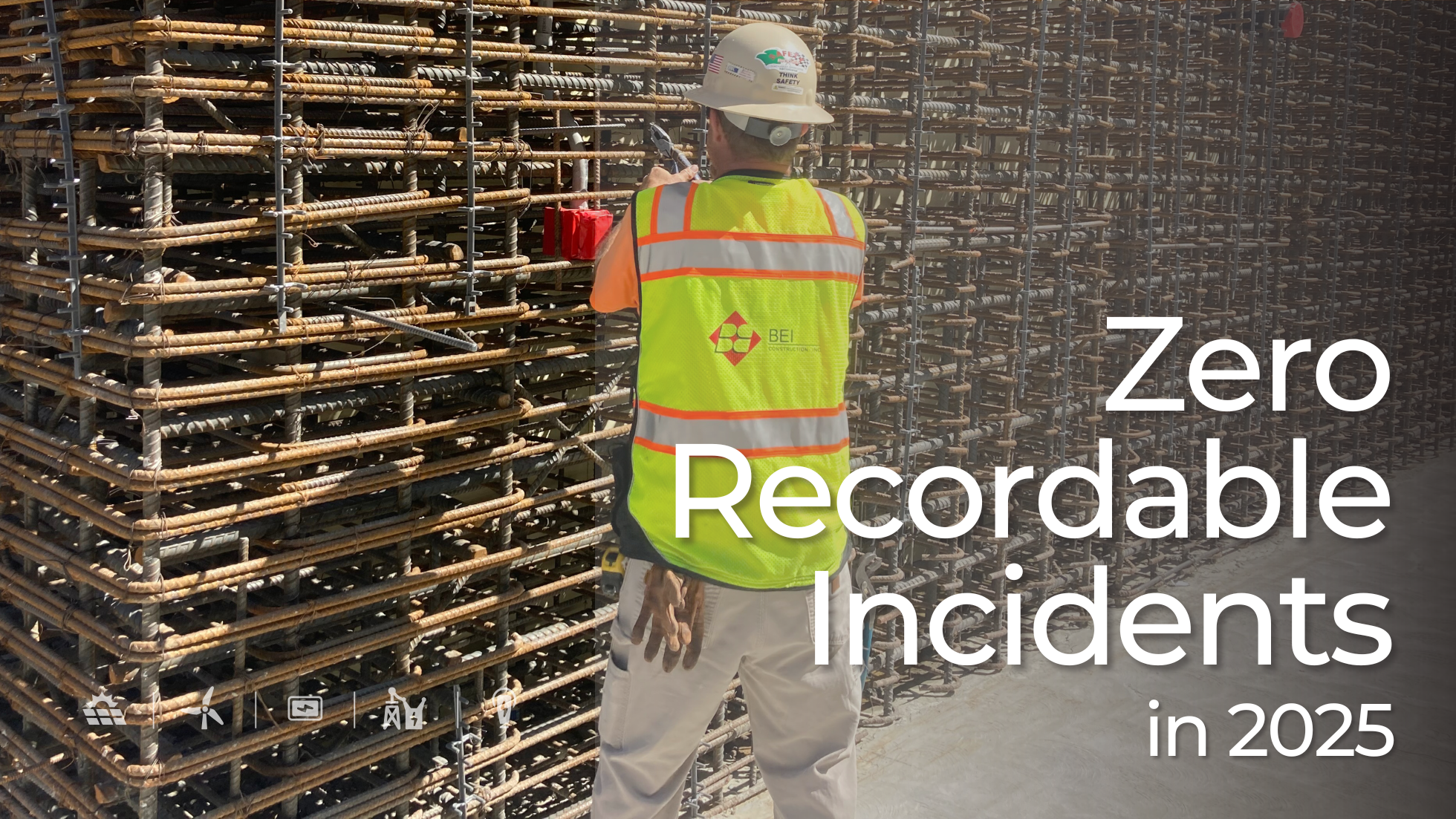 Construction worker wearing BEI safety vest while inspecting stacked steel rebar at a commercial jobsite. Text overlay reads: Zero Recordable Incidents in 2025.